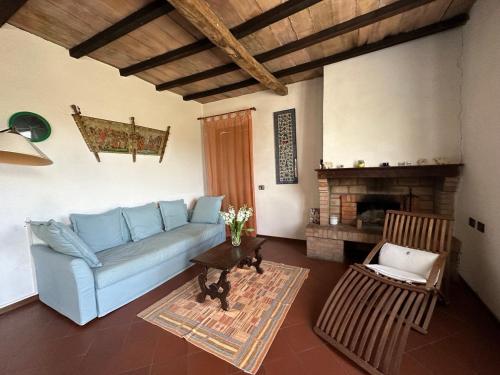 a living room with a blue couch and a fireplace at L'Aiolina in Vagliagli