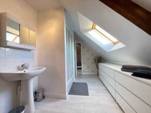 a white bathroom with a sink and a window at Les écuries à 12 mn de Cabourg in Goustranville