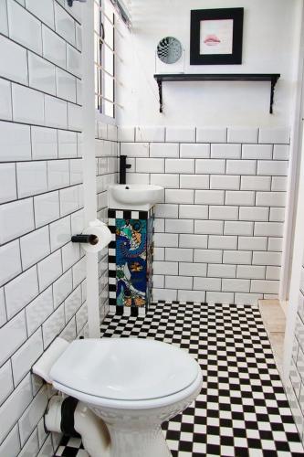 a bathroom with a toilet and a black and white tile floor at Gilcrest Place Guest House in Paternoster