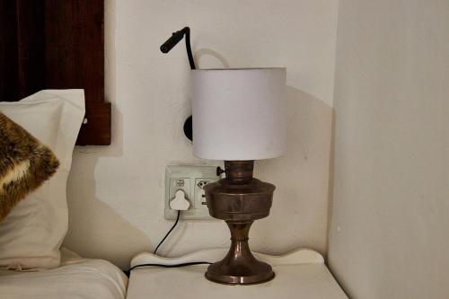 a lamp sitting on top of a bed next to an outlet at Gilcrest Place Guest House in Paternoster