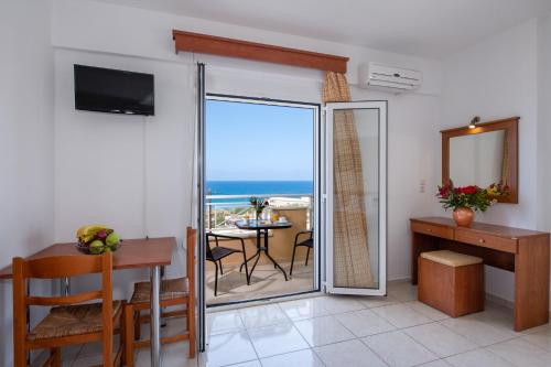a living room with a table and a view of the ocean at Sunrise Apartments in Sfakaki