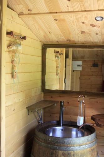 La salle de bains est pourvue d'un lavabo dans un tonneau et d'un miroir. dans l'établissement Roulotte irlandaise Polly, à Saint-Vincent-en-Bresse