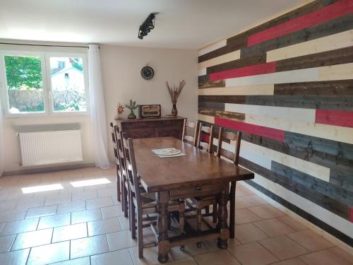 a dining room with a wooden table and chairs at Gîte des trois petits oiseaux in Picarreau