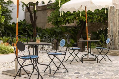 a group of chairs and tables with an umbrella at Casa Palacio Rufina & Jardines in Jerez de la Frontera