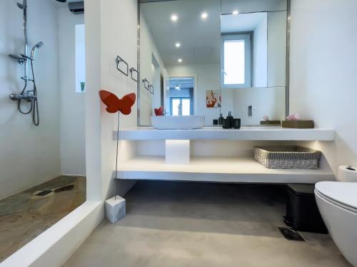 een badkamer met een witte wastafel en een toilet bij The Gallery Home in Andiparos