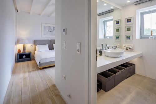 a bathroom with a sink and a bedroom with a bed at The Gallery Home in Antiparos