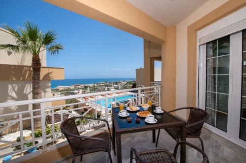 a balcony with a table and chairs and a view of the ocean at Sunrise Apartments in Sfakaki