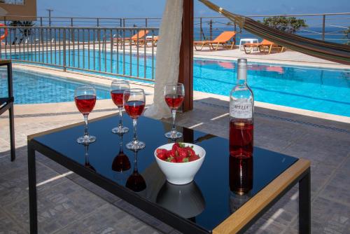 a table with wine glasses and a bowl of fruit at Sunrise Apartments in Sfakaki