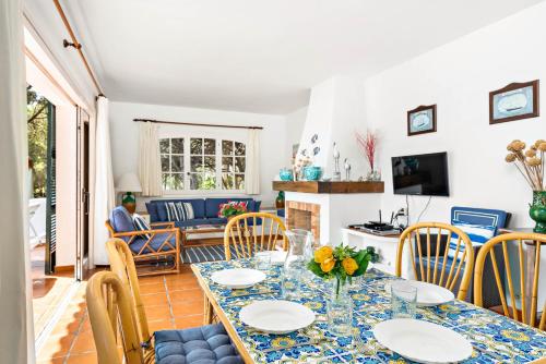 a dining room and living room with a table and chairs at Vista Mar in Cala Galdana