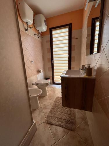 Un baño con inodoro, lavabo y espejo. en Casa Vacanze Pula, en Pula