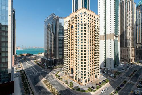 an aerial view of a tall building in a city at Marriott Executive Apartments City Center Doha in Doha