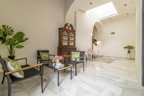 a living room with chairs and tables and a skylight at Casa Palacio Rufina & Jardines in Jerez de la Frontera