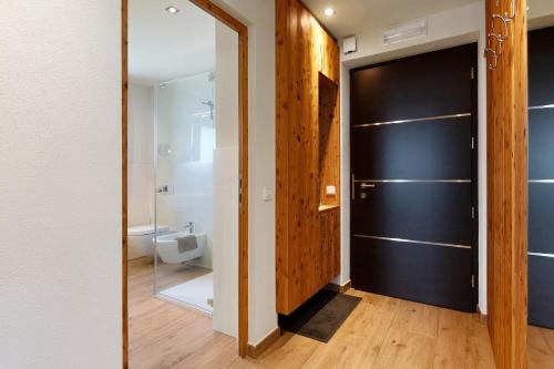 uma casa de banho com uma porta preta e um WC em Cornelia Latsche em Castelrotto