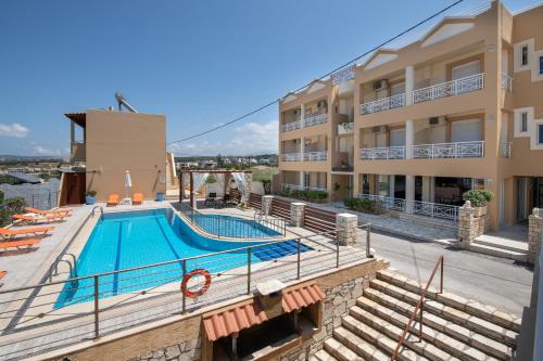 a building with a swimming pool next to a building at Sunrise Apartments in Sfakaki