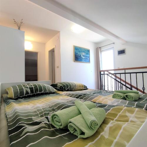 a bedroom with a large bed with green pillows at New apartments Kunić Sobra-Mljet in Sobra