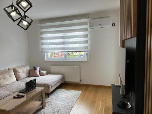 a living room with a couch and a television at Stan na dan Lorena in Sarajevo
