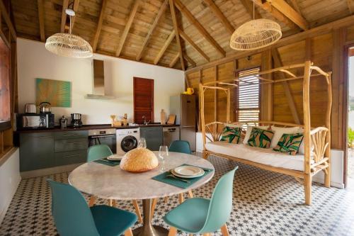 a kitchen and dining room with a table and chairs at Bungalow La Coulée d'Or in Le Vauclin