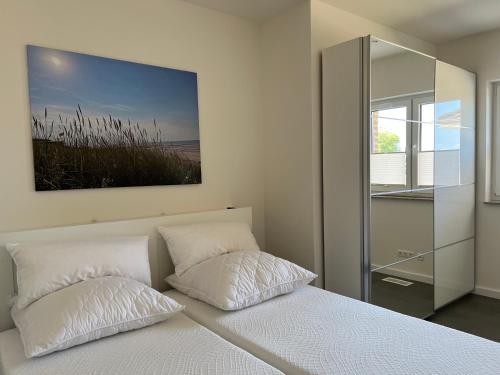ein Schlafzimmer mit einem Bett mit zwei Kissen und einem Spiegel in der Unterkunft Ferienhaus RELAX in Büsum