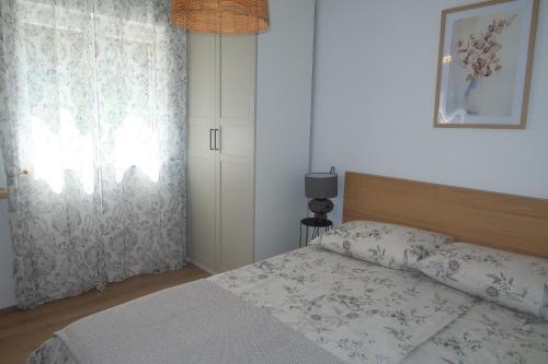 a bedroom with a bed and a window at Apartments Matea in Baška
