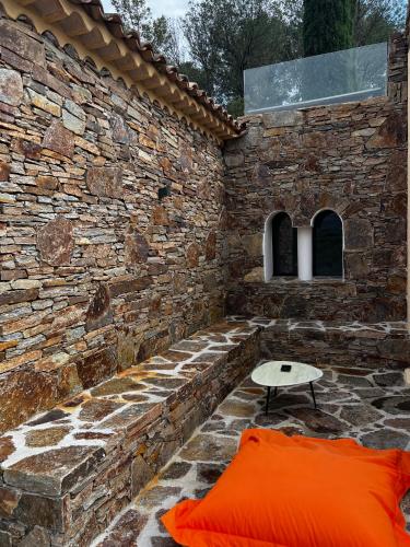 a stone wall with a bench and a table at Villa familiale avec vue imprenable in Saint-Raphaël