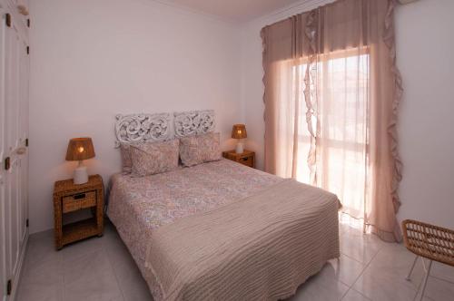 a bedroom with a large bed and a window at Waves by OCvillas in Albufeira
