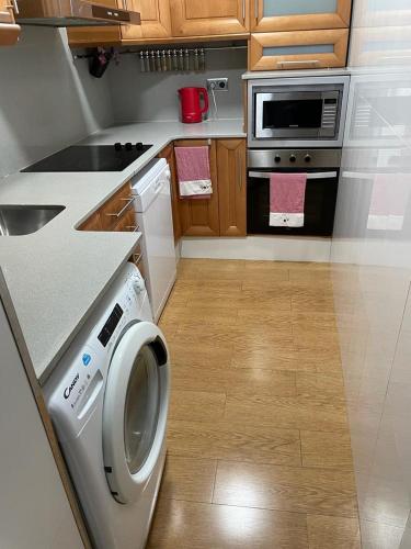 een keuken met een wasmachine en een fornuis bij Cozy Flat in Barcelona