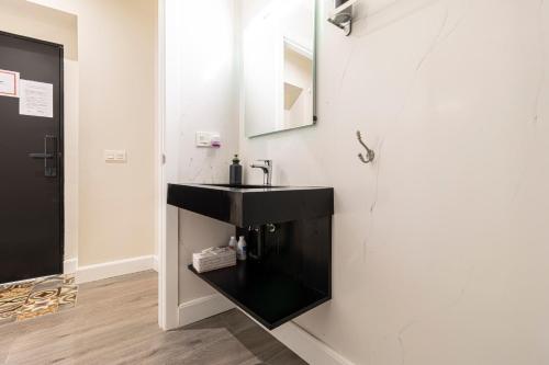 a bathroom with a black sink and a mirror at Casa Palacio Rufina & Jardines in Jerez de la Frontera