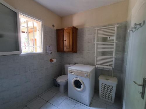 een badkamer met wasmachine en toilet bij Gîte Rosa et Jean-Jacques in Aigues-Mortes
