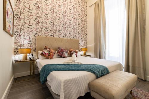 a bedroom with a bed with a floral wallpaper at Casa Palacio Rufina & Jardines in Jerez de la Frontera