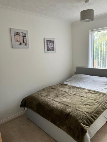 a white bedroom with a bed and a window at Seaside Haven in Hunstanton