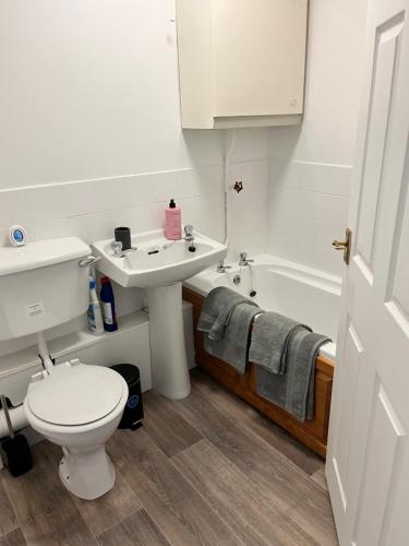uma casa de banho com um WC, um lavatório e uma banheira em Seaside Haven em Hunstanton