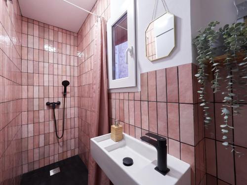een badkamer met roze betegelde muren en een wastafel bij Almodovar Apartment Barcelona in Barcelona