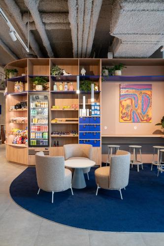 a room with a table and chairs and shelves at ibis budget Gent Centrum Dampoort in Ghent
