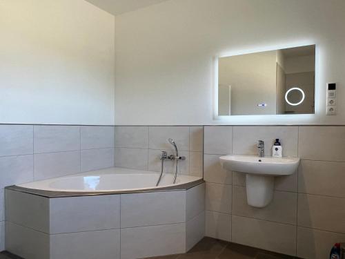 a bathroom with a tub and a sink and a mirror at Ferienhaus RELAX in Büsum