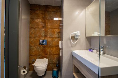 a bathroom with a toilet and a sink and a mirror at Class Unique Beach in Marmaris