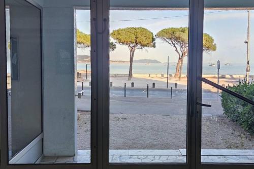a view of a beach from a window at La Ciotat, appartement rénové en bord de mer in La Ciotat