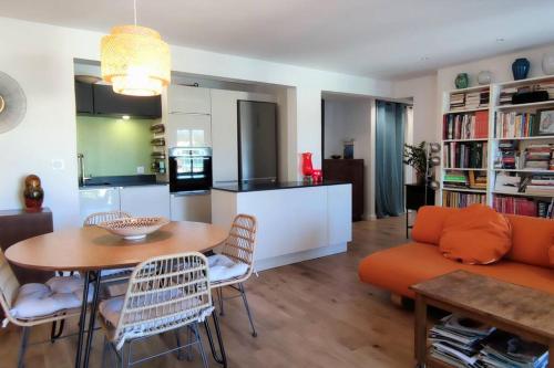 a living room with a couch and a table and a kitchen at La Ciotat, appartement rénové en bord de mer in La Ciotat