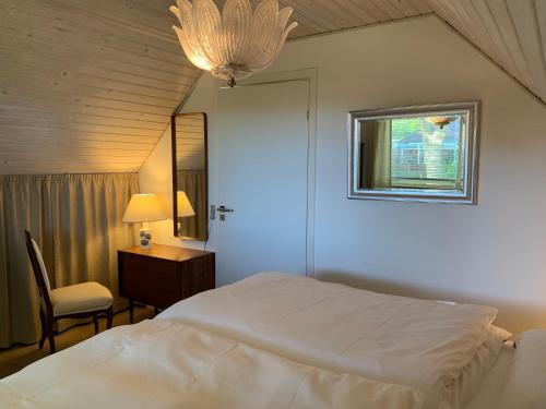 a bedroom with a bed and a desk and a window at Kollund Cottage in Kruså