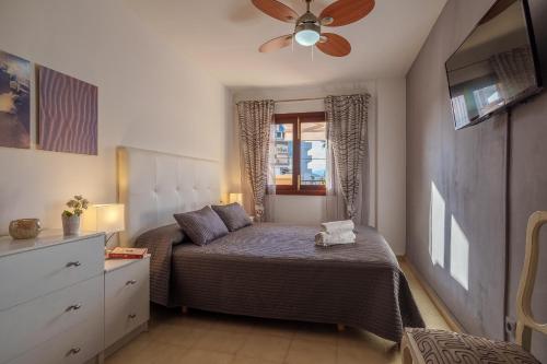 - une chambre avec un lit et un ventilateur de plafond dans l'établissement Ideal Property Mallorca - Nice 4 You, à Port d'Alcúdia