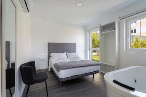 sypialnia z łóżkiem, wanną i umywalką w obiekcie Solpor Galitrips - Apartamentos Corcubión w mieście Corcubión
