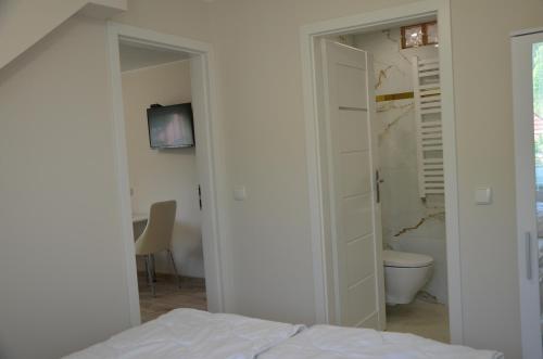 a bedroom with a bed and a bathroom with a toilet at Apartament Magurka 1 in Rycerka Górna
