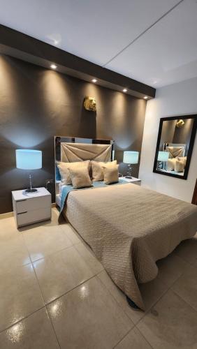 a bedroom with a large bed with two lamps on it at Linving buenos aires in Medellín
