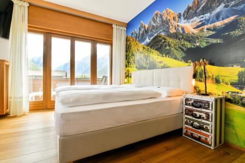 a bedroom with a mountain mural on the wall at Guesthouse Rosengarten in Dobbiaco