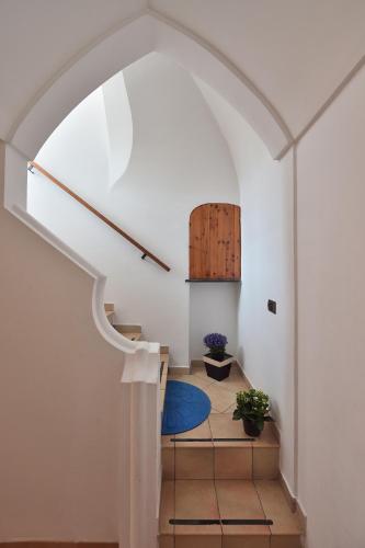 a hallway with an archway and a blue rug at Luna Rossa in Minori