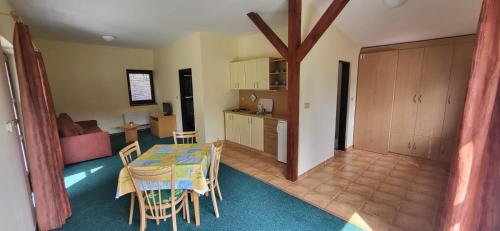 a kitchen and a dining room with a table and chairs at APARTMÁNY SMRAĎAVKA č.ev.52 in Buchlovice
