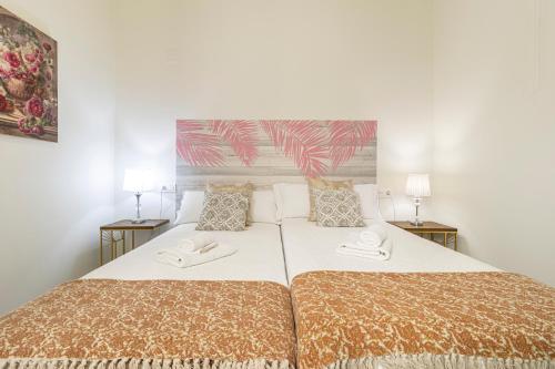 a bedroom with two beds and two lamps at Casa Palacio Rufina & Jardines in Jerez de la Frontera