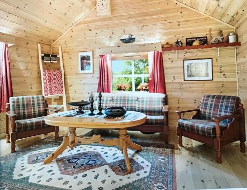 a living room with a table and chairs in a cabin at Perlen på solheim I Hyen in Vereide