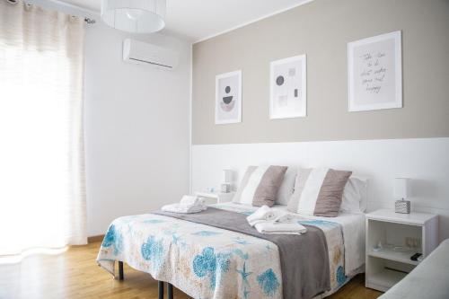 een witte slaapkamer met een bed met een deken bij B&B Pitagora in Crotone