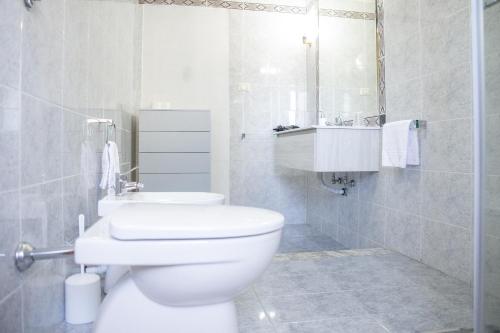 bagno bianco con servizi igienici e lavandino di B&B Pitagora a Crotone
