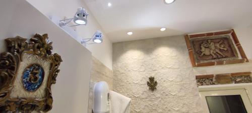 a bathroom with a clock on the wall next to a door at Villa Arianna B&B in Taormina
